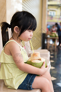 可爱女孩饮椰子水旅行热带街道女性稻草孩子们孩子果汁童年食物图片