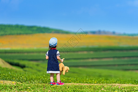 一个女孩站在绿草地上公园蓝色头发童年裙子幸福快乐婴儿场地孩子图片