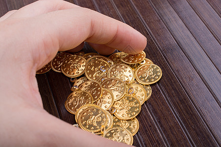 手头有很多假金币金融硬币财富货币现金概念宝藏商业金属金子图片