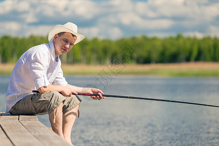 经验丰富的渔民坐在木头码头上 在TH捕鱼图片