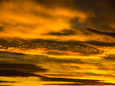 明亮的金色天空 黄昏日落时有彩云照亮风景橙子气氛阳光场景射线天气气候天堂风暴图片