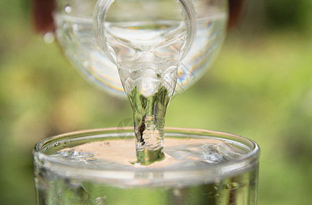 根据自然背景将水从瓶子倒到杯子的人矿物绿色宏观桌子白色苏打运动饮料塑料生活图片