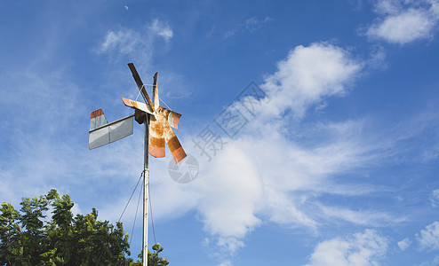 蓝色天空下老旧的生锈风力涡轮机图片