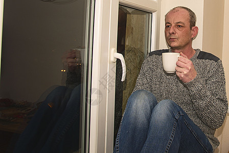压抑的中年男子坐在窗户旁边 悲哀的人喝咖啡 心软图片