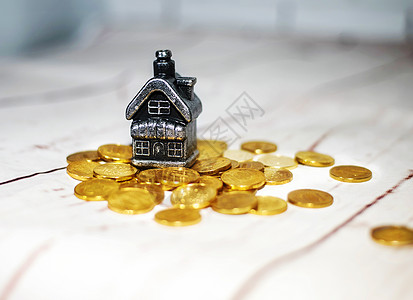 房子靠着一堆硬币 现金储蓄的概念建筑小屋住宅安全抵押账单庇护所储蓄构造商业图片