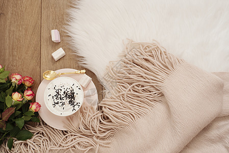 卡布奇诺 一束玫瑰花 以及地板上白毛地毯上的一条温暖围巾花束金子奢华早餐咖啡木头桌子生活假期乡村图片