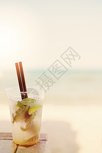 沙滩上的莫吉托鸡尾酒 海滩背景模糊 太阳 太阳烟雾 玻璃果汁叶子酒精天空海岸水果支撑饮料草本植物阴霾图片