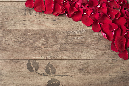 木制背景上的红色玫瑰花瓣 在一张木桌上的玫瑰花瓣边框 顶视图 复制空间 花卉框架 风格营销摄影 婚礼 礼品卡 情人节或母亲节背景图片