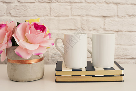 两个马克杯 白色杯子样机 空白的白咖啡杯模拟 风格的摄影 咖啡杯产品展示 条纹设计笔记本上的两个咖啡杯 粉红玫瑰花瓶照片饮料庆典图片