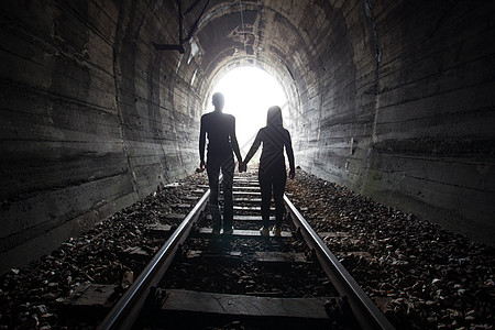 一对夫妇一起走过铁路隧道 穿过一条铁路隧道移民逃犯难民女士圆形避难所男人希望拱形风险图片