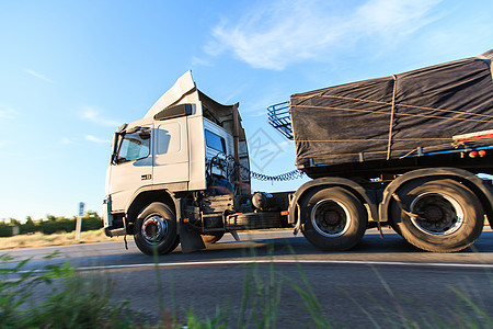 上午亮光时乘坐公路卡车驾驶速度车辆交通后勤天空运输沥青送货货物图片