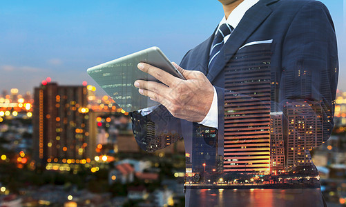 商务人士使用现代数字平板电脑的双重曝光城市营销工作套装成功办公室景观网络商务研究图片