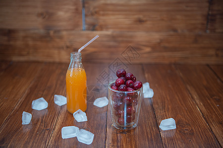 甜樱桃 木背景玻璃杯中的黑樱桃 玻璃瓶中新鲜多汁叶子木头甜点桌子生活团体浆果农业果汁玻璃图片