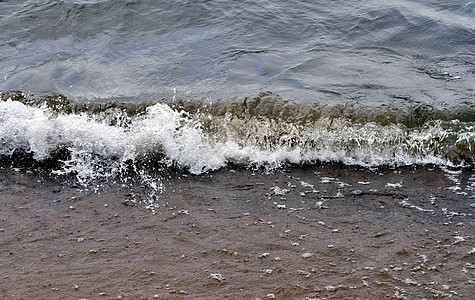 即将到来的波浪会喷出大量的喷雾海岸线海滩海浪泡沫魔法支撑冲浪岩石全景水滴图片