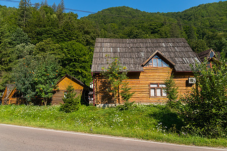 在青山蓝天的背景下 紧邻马路的原木木屋图片