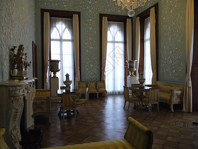 装饰华丽的淡蓝色起居室采用 18 和 19 世纪风格的 sienes 灰泥造型 配有白色壁炉 水晶吊灯 米色-金色古董家具和高高图片