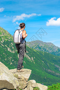 从山中背着背包的游客的背上地平线岩石闲暇活动远足女士冒险顶峰爬坡女孩图片