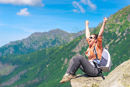 一名成功的旅游者 他坐在山上并享有自由图片