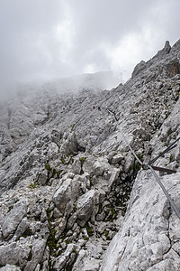 在巴伐利亚的Zugspitze通过登山绳索马具远足运动电缆安全岩石头盔顶峰图片