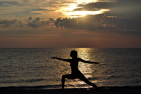 妇女练瑜伽 日落时站在维拉巴德拉萨纳的姿势图片