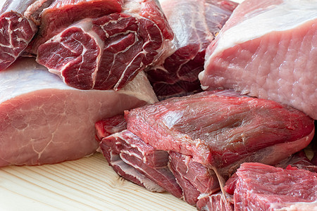 不同种类的生猪肉和牛肉 木制塔上的生肉屠夫桌子木板红色猪肉牛扒白色厨房营养食物图片