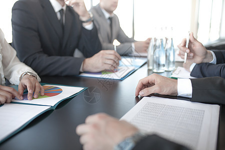 商业界人士讨论各种报告合作简报会议同事文书桌子办公室团队头脑男人图片