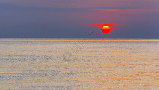 美妙的日出在平静的海面上图片