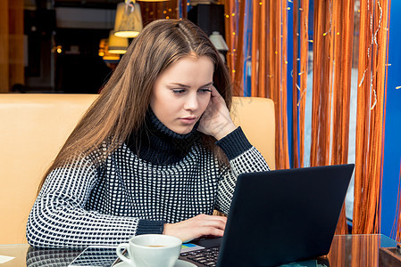 在咖啡馆工作用笔记本电脑和喝酒的年轻美女互联网技术微笑咖啡餐厅咖啡店女孩成人成功阅读图片