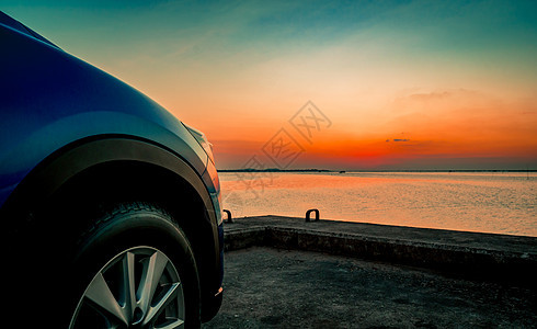 日落时分 蓝色紧凑型 SUV 车停在海边的水泥路上 采用运动和现代设计 环保技术 商业成功理念 混合动力汽车 汽车行业越野车天空背景图片