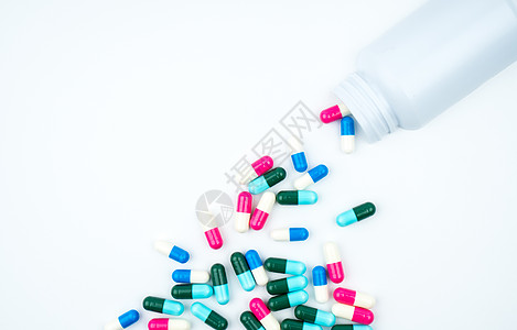 抗生素胶囊从白色背景的药瓶中溢出 带有复制空间 只需添加您自己的文本 抗生素用药要有合理的概念 抗菌药物滥用 医药行业 药房背景图片