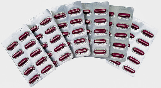 红胶囊药丸堆积在充气袋中 配有剪切路径 维生素和补充物概念 医药包装工业 药剂背景图片