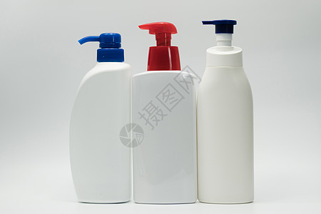 三瓶装有红色和蓝色泵的白色酒瓶图片