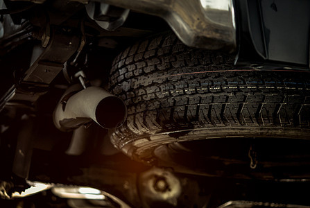 汽车下面的轮胎接近排气管 车轮 橡胶制品 在旅行概念之前检查车辆图片