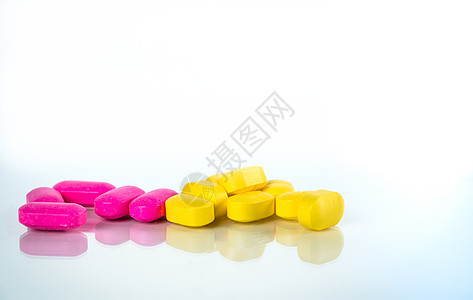 黄色和粉红色的椭圆形药丸 白色背景上有阴影 带有文本复制空间 轻度至中度疼痛管理 止痛药 布洛芬胶囊丸图片