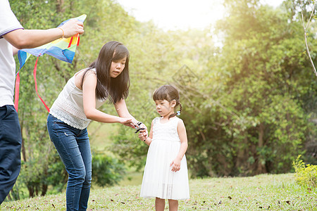亚洲家庭在户外公园放风筝图片