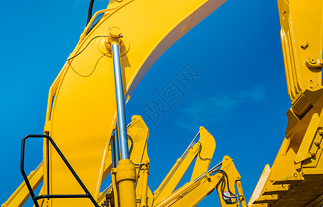 有水力活塞胳膊的黄色挖掘机反对清楚的蓝天 用于在施工现场进行挖掘的重型机械 液压机械 巨大的推土机 重工业技术建筑伤害工程人身机图片
