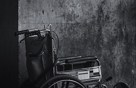 轮椅折叠在墙边 医院概念的悲伤消息 萧条与老龄化社会 孤独的空轮椅 服务病人和辅助残疾老人的医疗设备助手护理车轮死亡老年黑与白椅图片