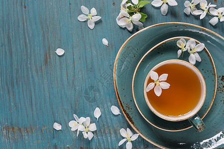 绿色卡通茶树花绿茶和苹果树花乡村蓝色框架插图饮料制品陶瓷杯子木板花瓣背景