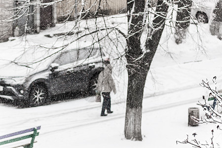 一个路过者在大雪中穿过寒雪的市区院子风暴季节血统气候漂移假期男性降雪场景街道图片
