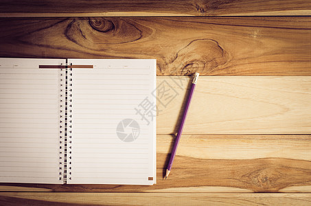 杯子里的彩色铅笔和放在桌子上的笔记本草图海报笔记艺术学校办公室木头控制板螺旋羊皮纸图片