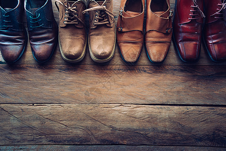 男子在木制地板上穿不同样式的鞋     生活方式桌子凉鞋男人商业男性工作戏服旅行奢华地面图片