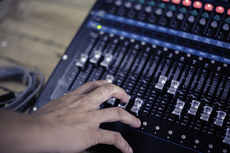 DJ正在调整声音的音量 专业音频控制生产均衡器音板岩石按钮广播流行音乐播送技术员图片