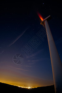夜间风力涡轮机与城市灯光涡轮日落股票力量天空风车时间环境月亮太阳图片