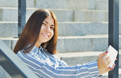 持有平板牌和用视频交谈的年轻女学生学习微笑喜悦女孩大学互联网女性成人快乐技术图片