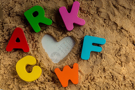 沙子上写着心形和彩色字母拼写孩子学者智商创造力家庭知识童年公司学生图片