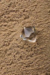 沙土背景的透明钻石Name石头火花白色玻璃水晶宝石珠宝美丽奢华岩石图片