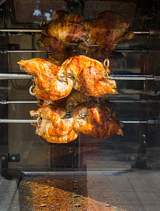 在展示中用金属旋转的金属烤鸡屠夫棕色炙烤午餐黄色店铺食物街道烘烤玻璃图片