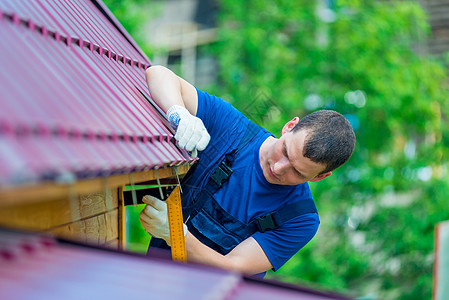 一名男子在修理房顶时用工具修理房屋屋顶图片