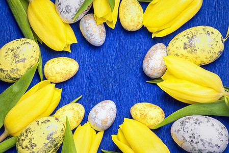 复活节快乐 黄色新鲜郁金香 在蓝色背景和复活节鸡蛋上桌子植物礼物季节花束庆典乡村假期风格卡片图片