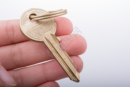 手握金色键金属房子安全秘密钥匙图片